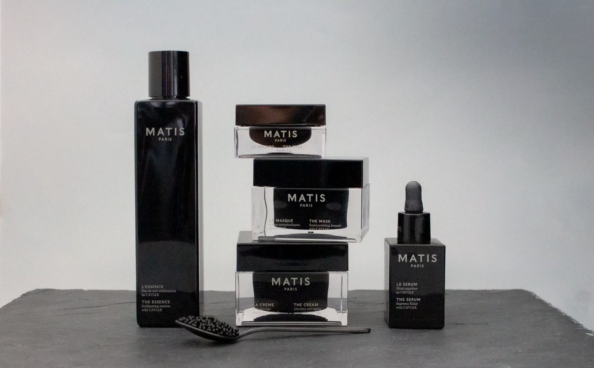 Prodotti skincare Matis Paris della linea al caviale: crema anti-età, siero, maschera ed essenza viso disposti su una superficie grigia